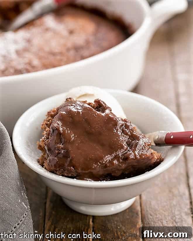 Easy Chocolate Pudding Cake served in a pristine white bowl, adorned with a vibrant red-handled fork, highlighting its rich texture and inviting appearance.