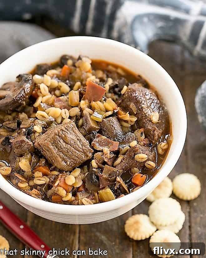 Overhead view of a beautifully presented Beef and Barley Soup in a white bowl, ready to be enjoyed.