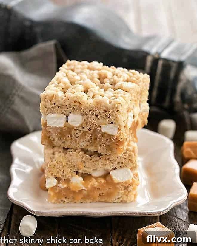 A closer view of a Caramel Stuffed Rice Krispie Treat on a square white plate, highlighting the distinct layers.