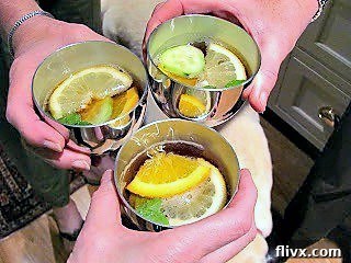 Toasting with Pimm's Cup in pewter cups, garnished with citrus, mint, and cucumber.