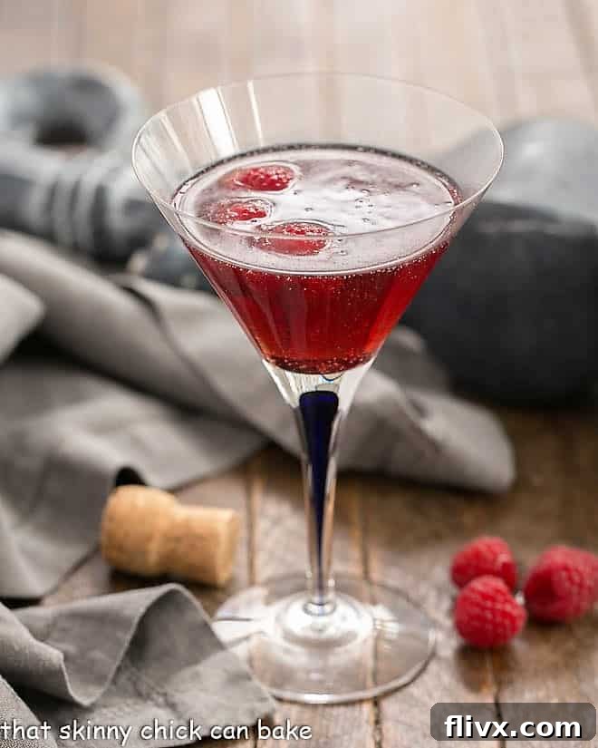 A Classic Kir Royale with Crème de Cassis served in a stylish blue-stemmed martini glass, showcasing its vibrant color and elegant presentation.