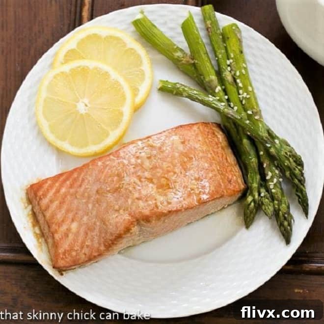 Grilled Cedar Plank Salmon - an easy, elegant recipe for grilling salmon Overhead view of grilled salmon on a white plate with asparagus and lemon slices
