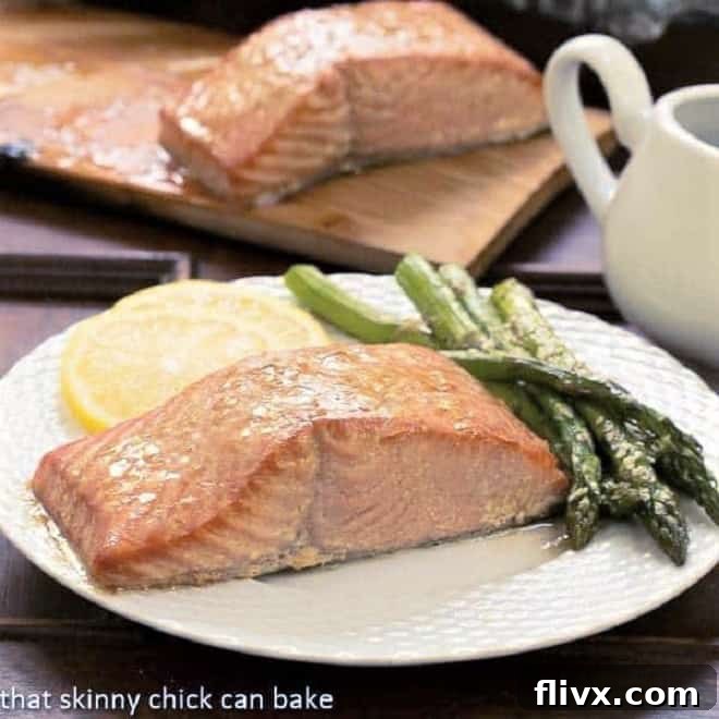 Plank grillin salmon infuses smoky nuances into the seafood from the fragrant cedar Grilled Cedar Plank Salmon on a white plate with asparagus