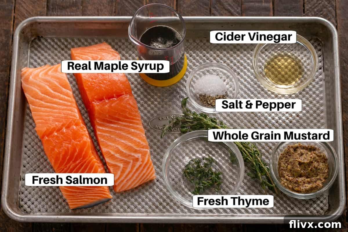 Sweet and Tangy Maple Mustard Salmon 2 All the ingredients for Maple Mustard Glazed Salmon, including fresh salmon fillets, maple syrup, whole grain mustard, cider vinegar, and fresh thyme, arranged on a baking sheet.