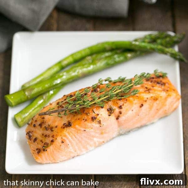Easy Salmon Recipe with Maple Mustard Glaze - A super easy glaze, then 15 minutes in the oven for a terrific entree! A single portion of Maple Mustard Glazed Salmon on a white square plate, garnished with fresh herbs.