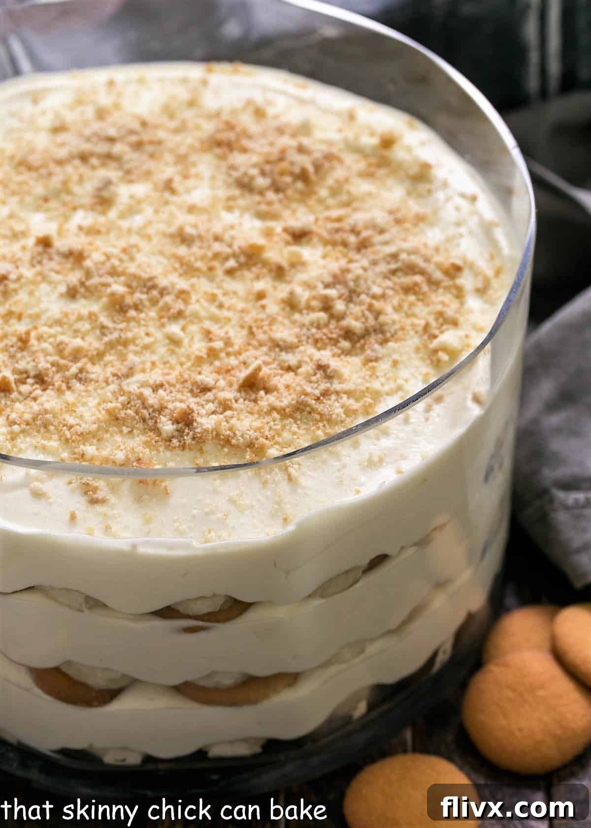 A large glass serving bowl filled with layers of creamy Easy Banana Pudding, adorned with vanilla wafers and sliced bananas.