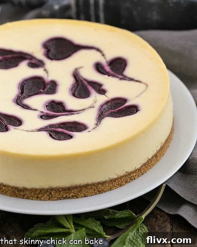 Uncut Blueberry Swirl Cheesecake on a white serving plate, showing perfectly set and creamy texture.