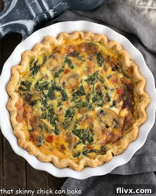 A golden-brown Spinach Mushroom Quiche cooling in a white ceramic pie plate, fresh out of the oven.