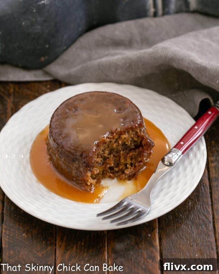Sticky Toffee Pudding on a white plate with a red handled fork.