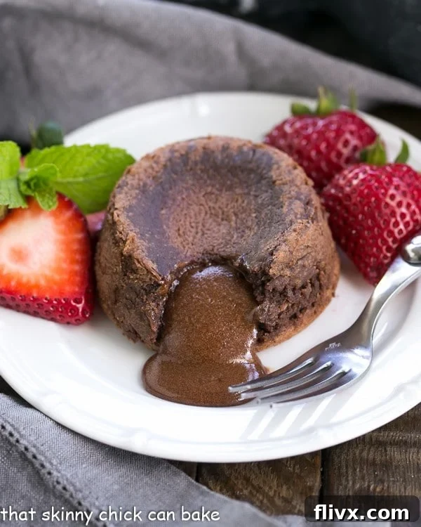 Lava oozing from a freshly baked chocolate lava cake, garnished with vibrant fresh strawberries, highlighting its irresistible gooey center and rich texture.