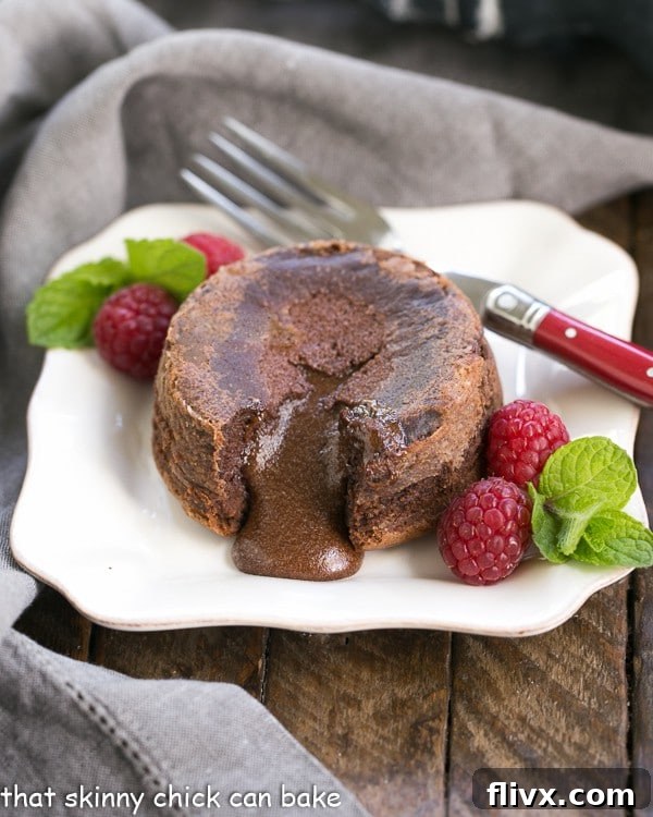 A classic chocolate lava cake on a pristine white plate, with a small portion removed to reveal its perfectly molten and rich chocolate core.