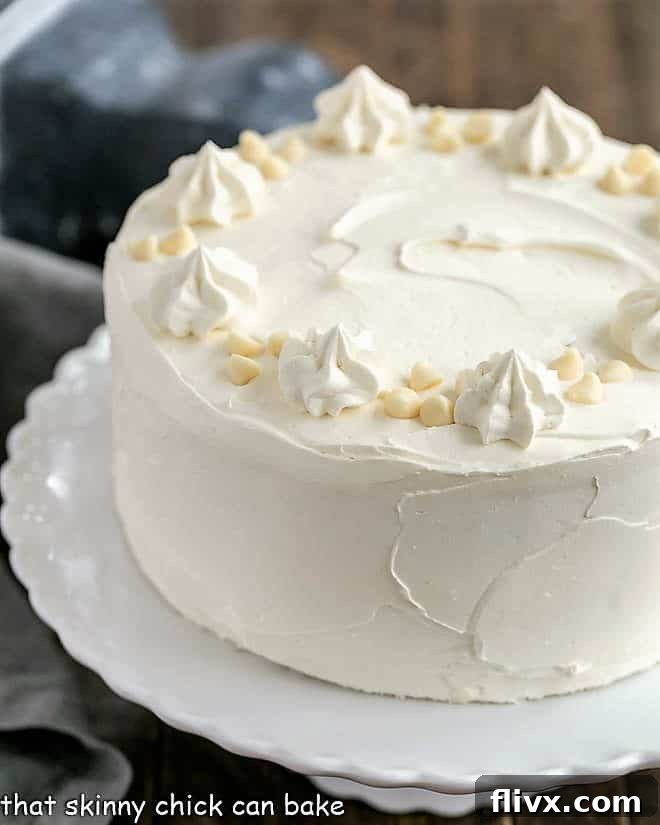 Classic White Layer Cake with White Chocolate Swiss Meringue Buttercream on a white cake stand, adorned for a celebration.