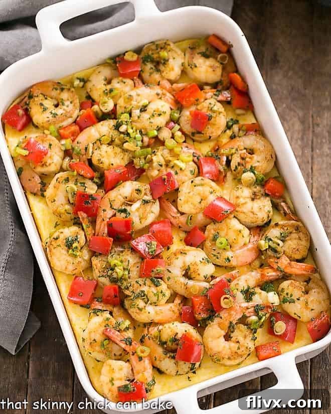 Cheesy Shrimp and Grits Casserole - flavorful, Creole spiced shrimp with a touch of heat blanketing tender, cheesy grits for an outstanding meal for the start or end of your day! Cheesy Shrimp and Grits Casserole in a white, rectangular casserole dish.
