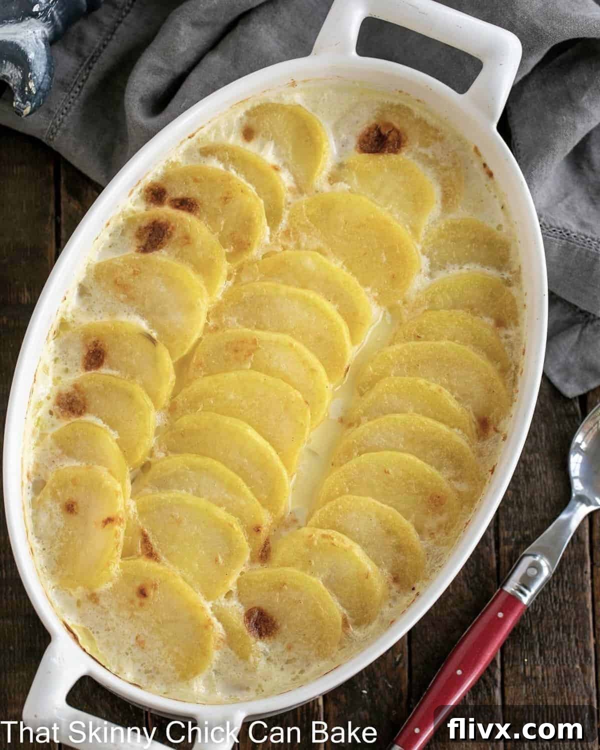 Overhead view of a large dish of cheesy scalloped potatoes, ready to serve.