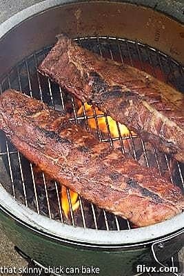 Two racks of Fall Off the Bone Baby Back Ribs browning on a hot grill, showing a beautiful sear before they are moved to the oven.