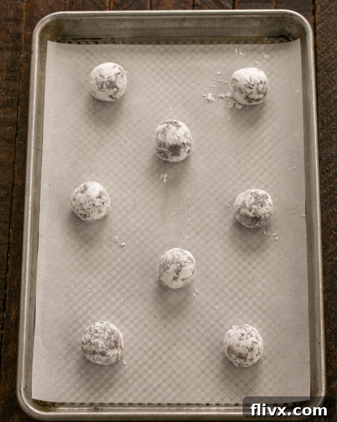Earthquake Cookies Step 8: Rolling chilled cookie dough balls in powdered sugar.
