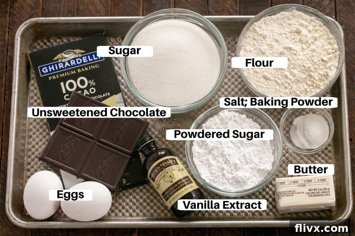 Fudgy chocolate earthquake cookie ingredients including flour, sugar, butter, eggs, unsweetened chocolate, baking powder, salt, and vanilla extract, neatly arranged on a sheetpan with labels.