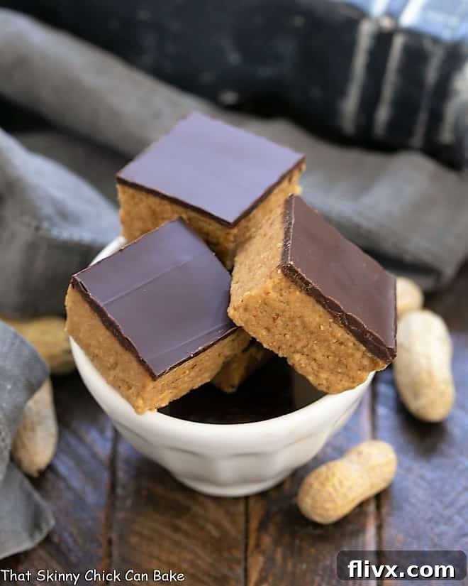 Decadent Better Than Reese's Peanut Butter Bars in a white bowl, showcasing their rich layers.