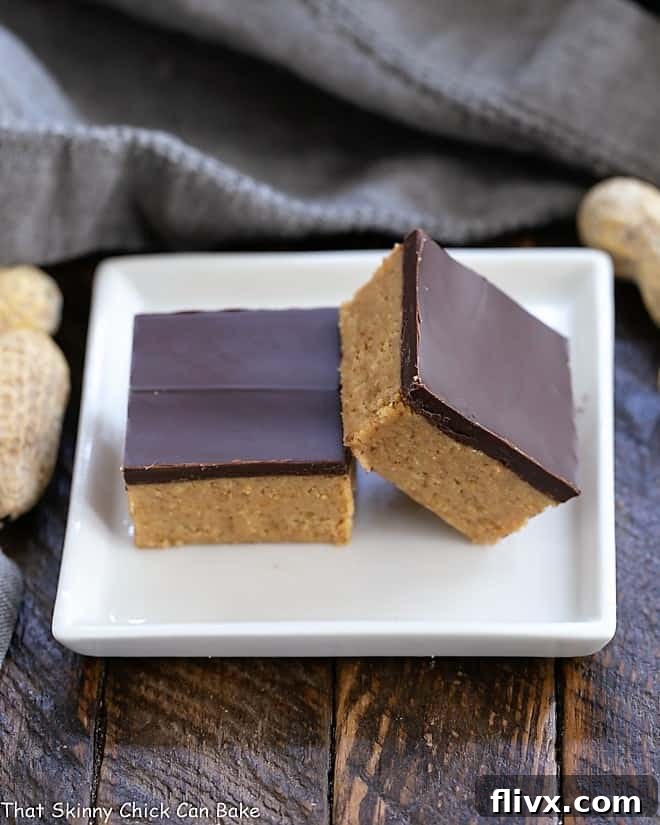 Two Better Than Reese's Peanut Butter Bars stacked on a small square white plate, ready to be enjoyed.