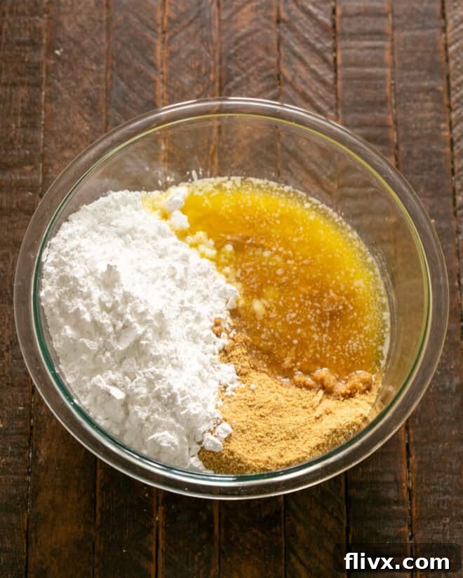 Step 2: Combine powdered sugar, graham cracker crumbs, smooth peanut butter, and melted butter in a large bowl.