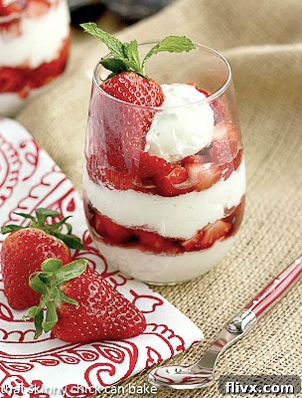 Strawberry Parfaits with a red handled spoon, red and white napkin and fresh strawberries, ready to be enjoyed.