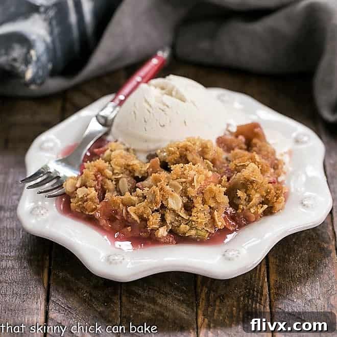 Easy Rhubarb Crisp on a white dessert plate with a scoop of ice cream