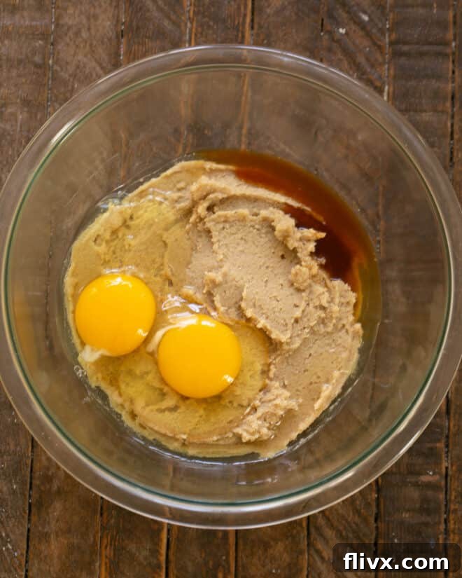 Step 2: Mixing eggs and vanilla extract into the creamed butter and sugar.