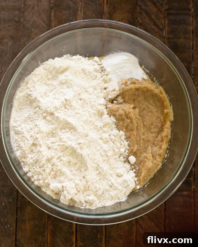 Step 3: Adding dry ingredients (flour, baking soda, salt) to the wet mixture.