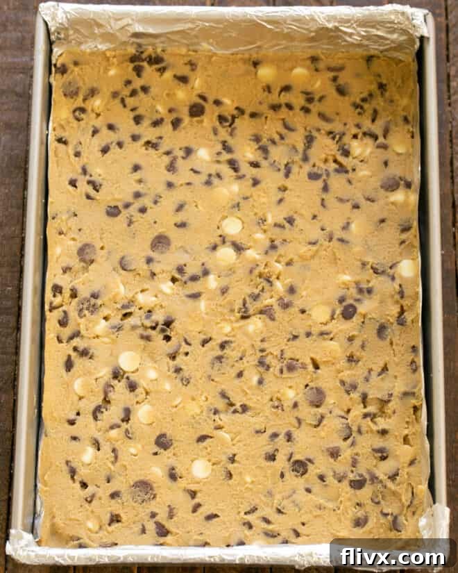 Step 6: Spreading cookie dough evenly into a lined baking pan.