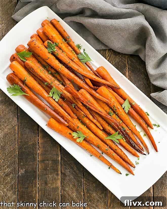 Overhead view of perfectly cooked Honey Balsamic Roasted Carrots, glistening with a sweet and savory glaze, served on an elegant white platter.