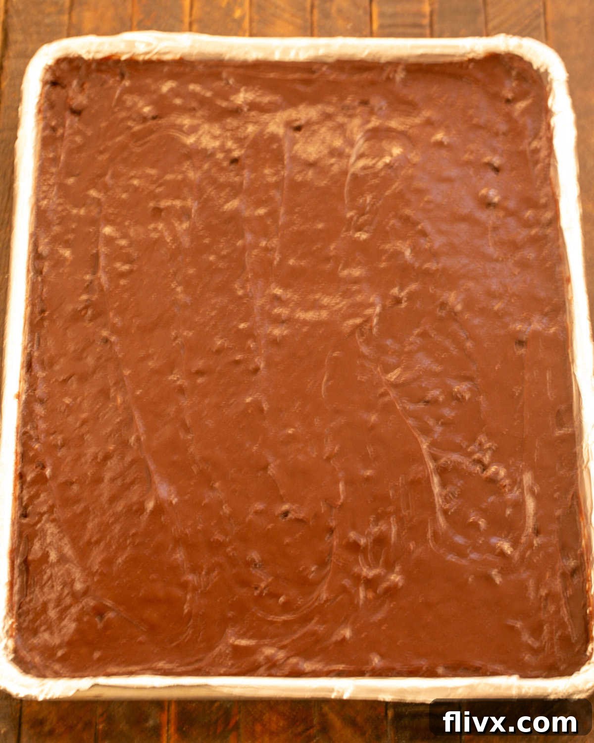 Step 9: Adding brownie batter to a lined baking sheet and smoothing the top.