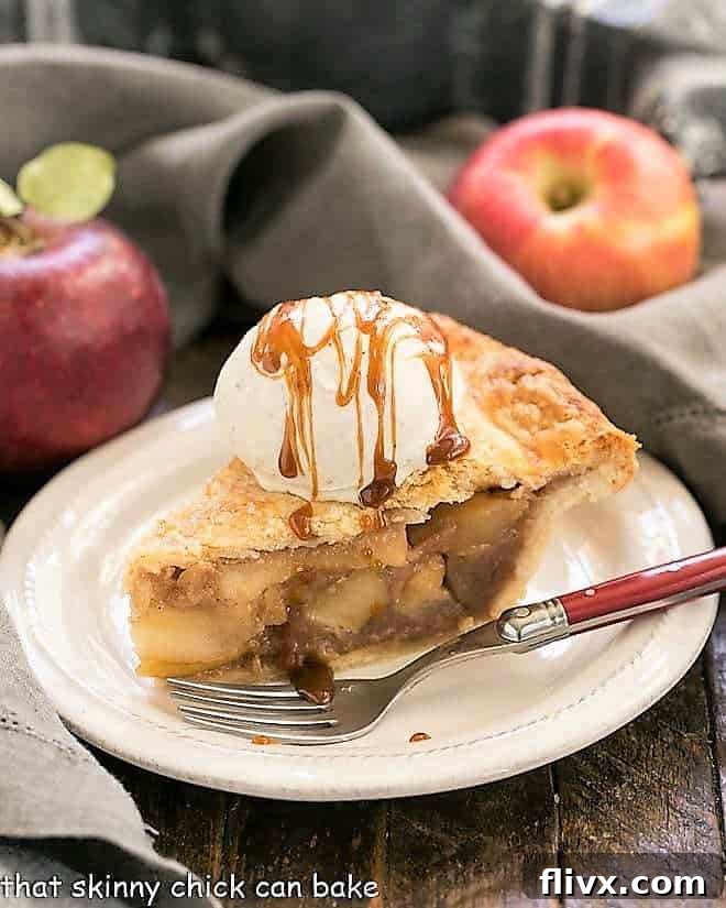 Slice of Caramel Apple Pie on a white plate with a red handled fork.