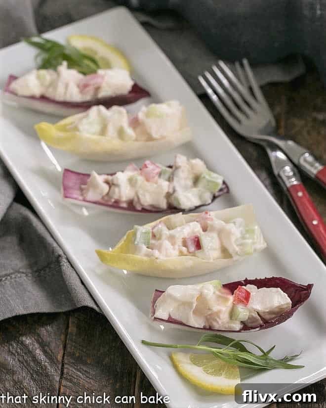 Lobster Salad in Endive Cups on a white tray with red handled forks