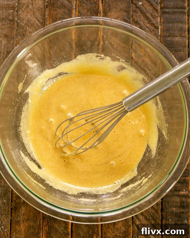 Step 2: Whisk together the egg and sugars until light and fluffy, creating the base for the cupcake batter.
