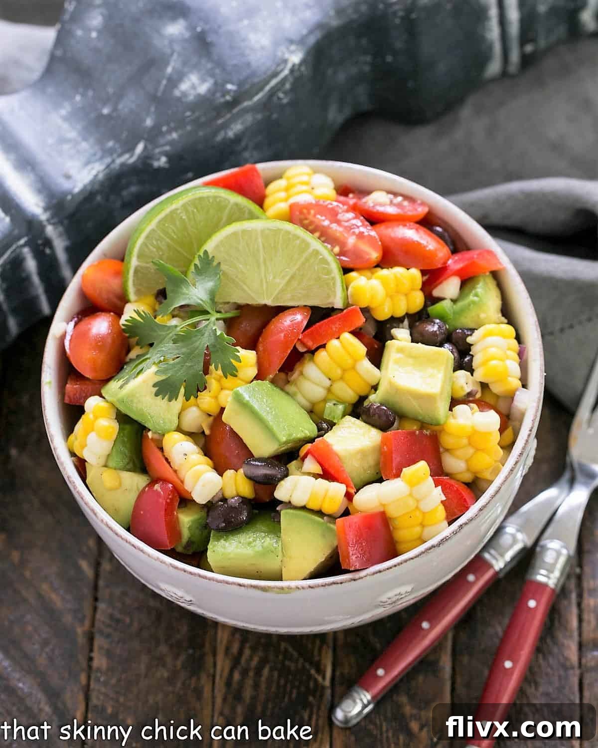 A beautifully presented Fresh Corn and Black Bean Salad with avocado in a white ceramic bowl, garnished with fresh cilantro, showcasing its vibrant colors and inviting texture. Ideal for summer gatherings.