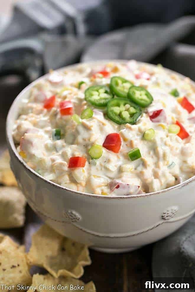 A vibrant Sour Cream Corn Dip Recipe, artfully presented in a pristine white serving bowl, ready to be enjoyed.