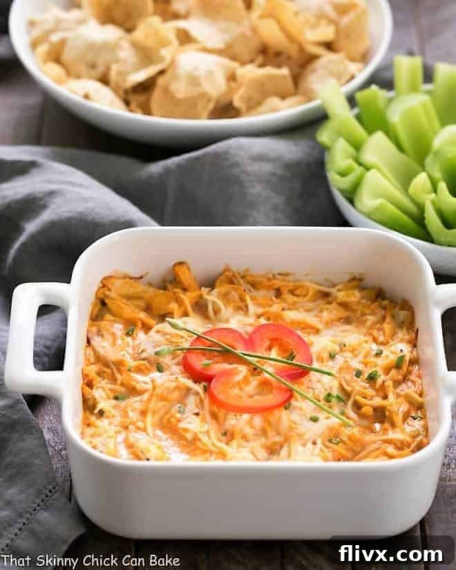 Buffalo Chicken Dip Recipe in a baking dish garnished with a pepper slice and chives.