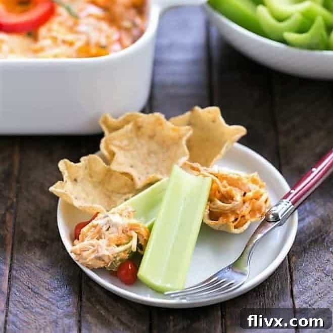 Buffalo Chicken Dip on a small appetizer plate with chips and celery.