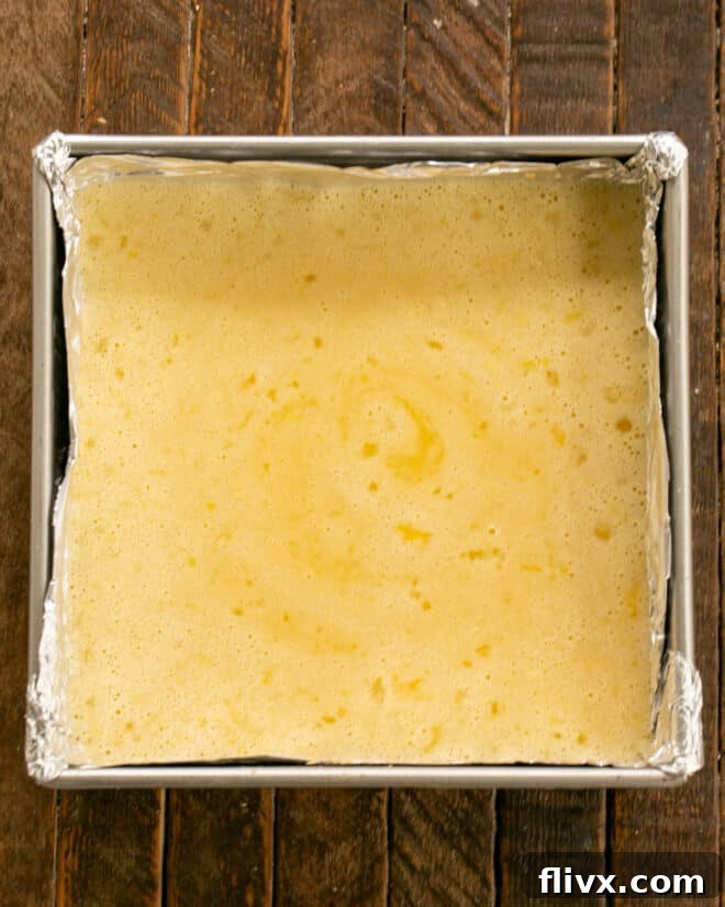 Lemon bars topped with custard, freshly baked with a firm, slightly browned topping.