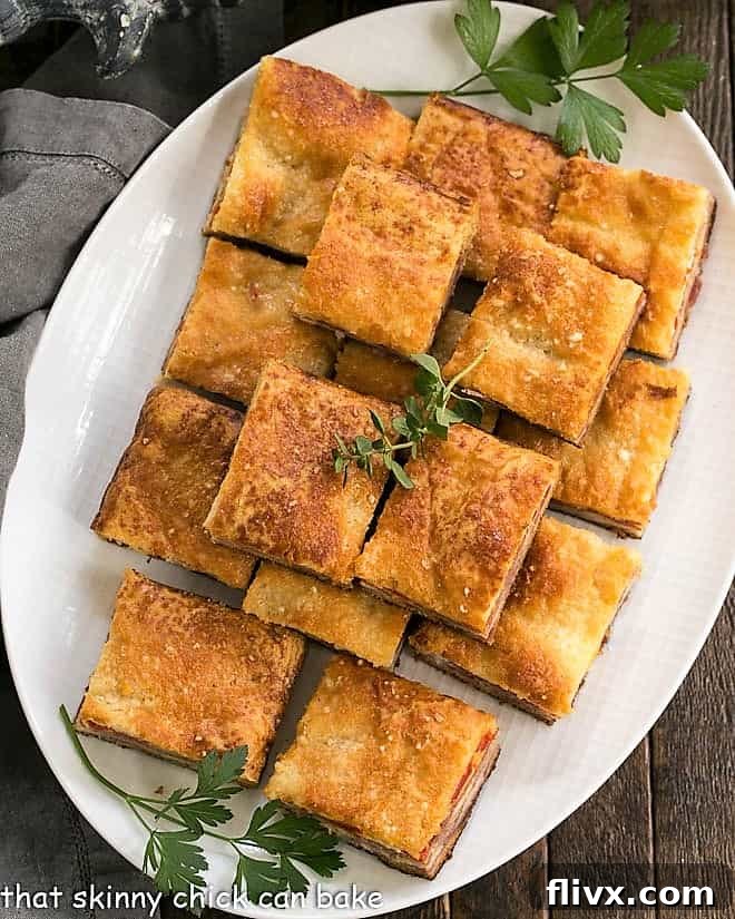 An overhead shot showcasing a platter of freshly baked Antipasto Squares, beautifully golden and ready for any party.