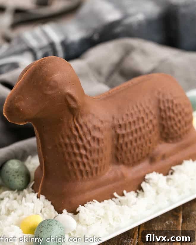 Fudge Lamb side view on a white tray of coconut on blue Easter eggs