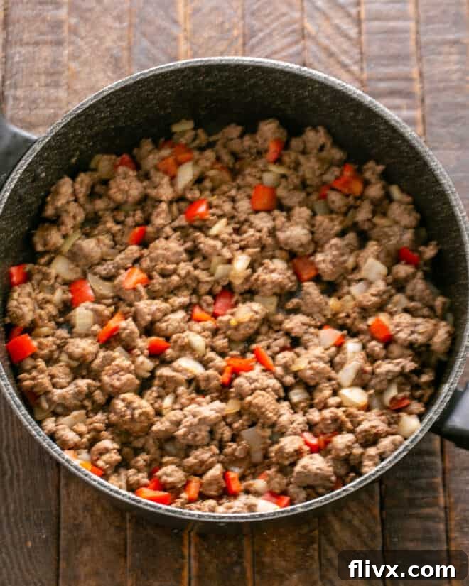 Soft Shell Tacos Step 2: Adding ground beef to the skillet with aromatics and breaking it apart to cook.