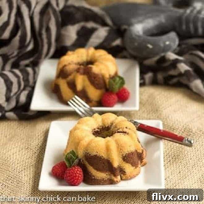 Two Mini Zebra Bundt Cakes on square white dessert plates, ready to be enjoyed as individual treats.