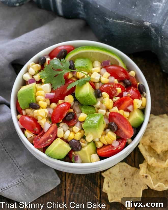 Overhead view ob black bean and corn salsa in a white serving dish with tortilla chips