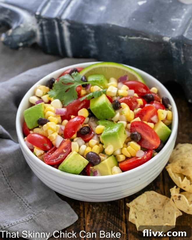 Corn salsa recipe in a white ceramic serving bowl with a cilantro garnish