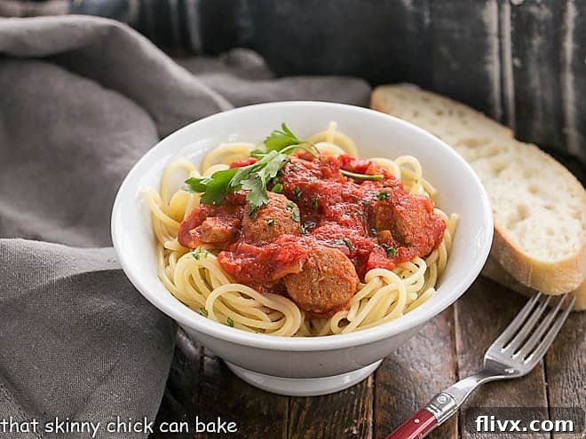 Homemade Pasta Sauce Recipe with Sausage in a white bowl with a red handled fork