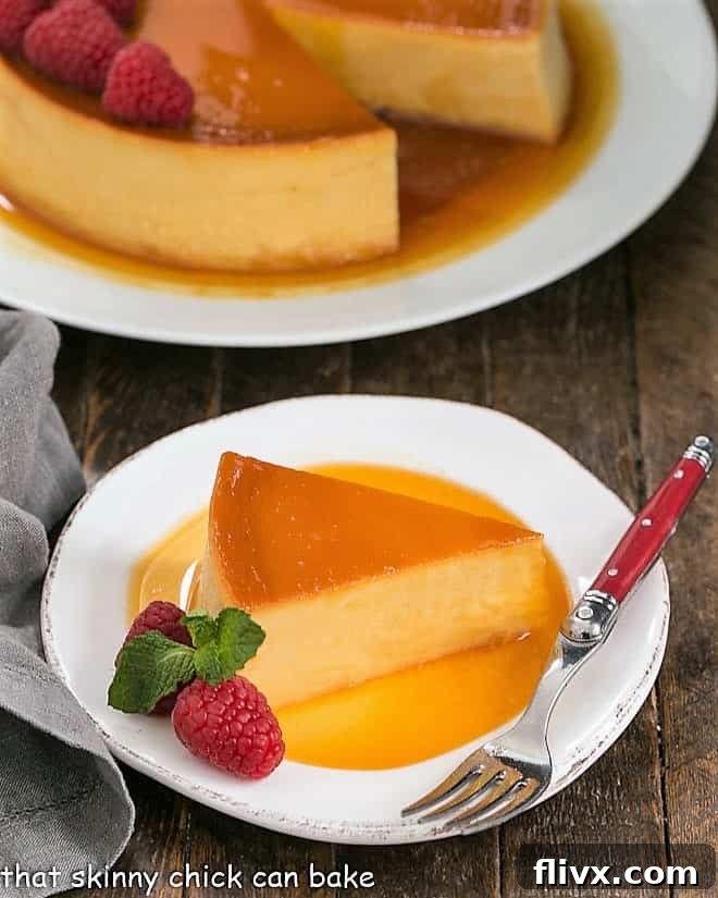 Slice of Leche Flan on a white plate with raspberry garnish. A rich and dreamy Caramel Flan Recipe, a cross between creme brulee and cheesecake, that everyone will want to lick their plates clean!