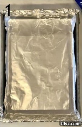 Baking pan lined with nonstick foil, ready for cheesecake bars preparation.