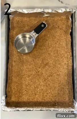 Crust mixture for cheesecake bars pressed into the bottom of a baking pan.