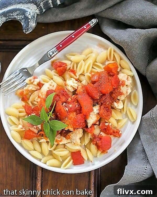 Overhead view of chicken feta casserole on a white plate, garnished with fresh herbs